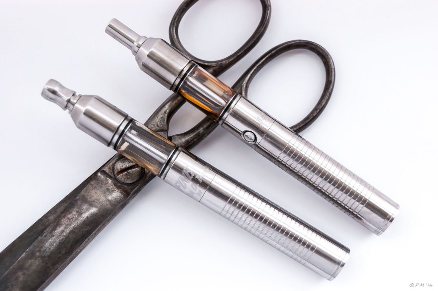 Two Fine Hybrid 14500 e-cigarettes by Iulian. O. Dorojan, Romania pictured with large scissors on white background. vape, gaping, e-cig 2014 eyeteeth.net