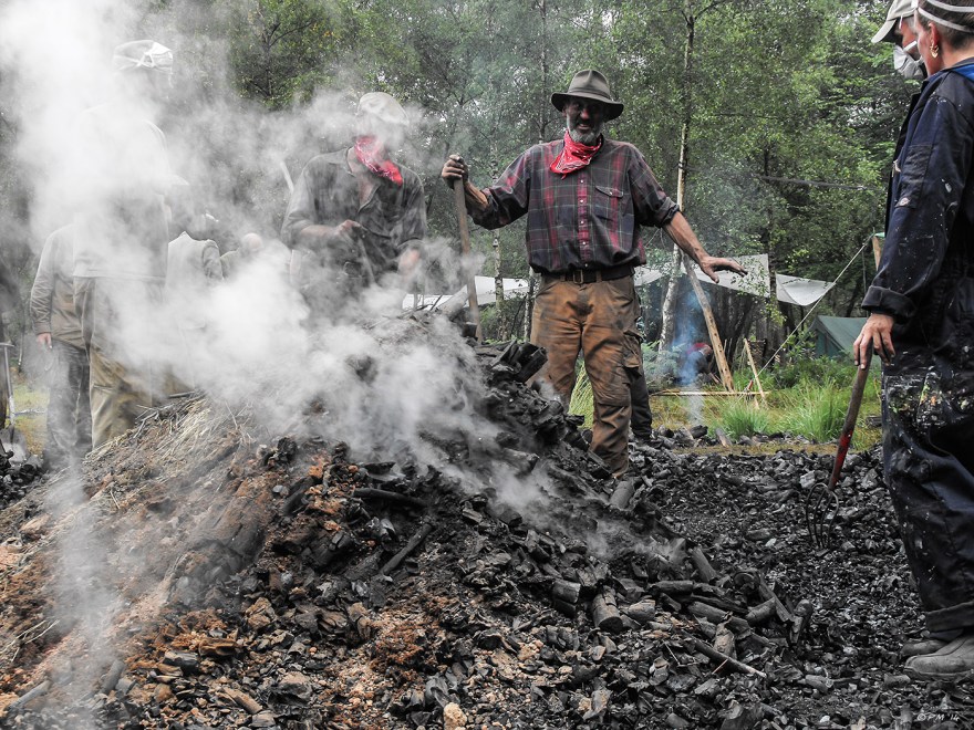 Traditional Charcoal Burning in Ashdown Forest Sussex, Alan Waters stand by as the charcoal is raked from the heap colour crafts history Britain Coppice Week 2010 P. Maton eyeteeth.net