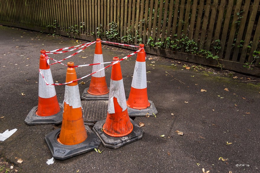 Traffic cones and tape around man hole cover in path Alum Chine Westbourne, Bournemouth P. Maton 2014 eyeteeth.net