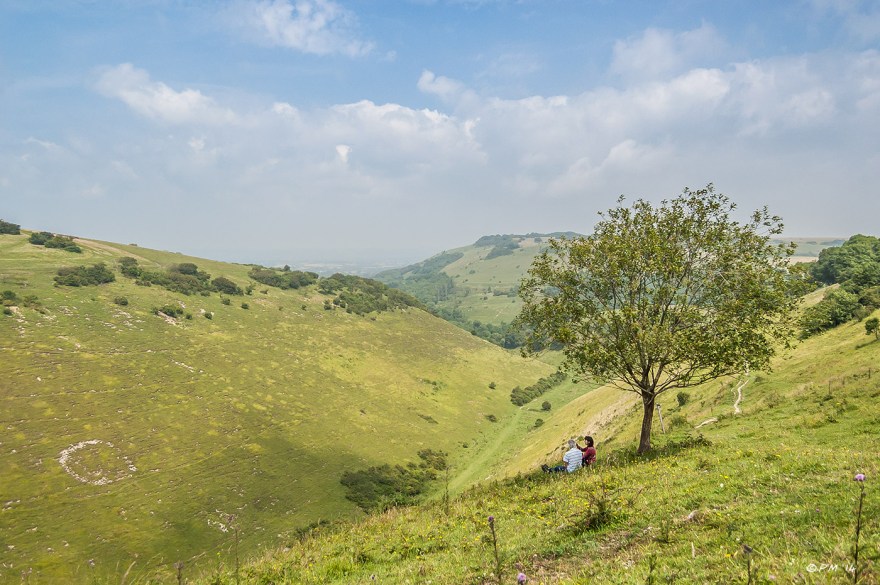 Couple sit in shade of tree on a sunny day overlooking Devils Dyke with Newtimber hill in distance, Sussex, South Downs National Park  P.Maton 2014 eyeteeth.net