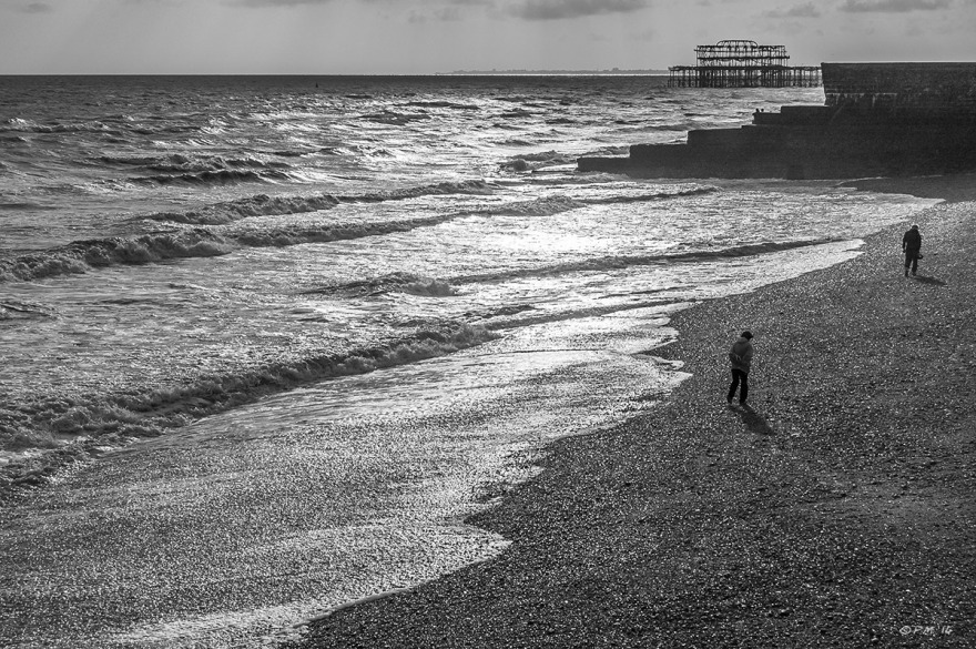 Two figures walking on Brighton Beach with Groyne and West Pier ruin in background Monochrome landscape P.Maton 2014 eyeteeth.net