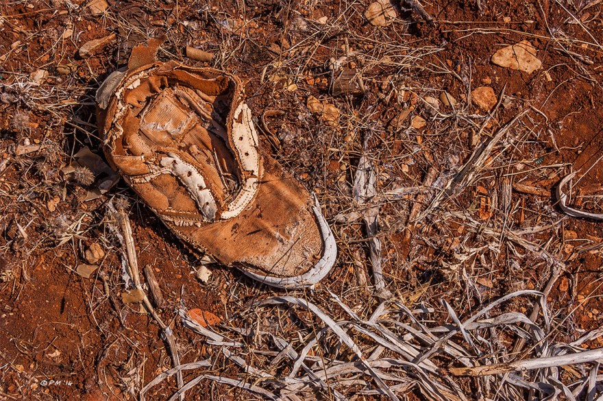 Abandoned old boot in red soil with dead grasses, colour. Patara Gelemis Turkey. P.Maton 2014 eyeteeth.net