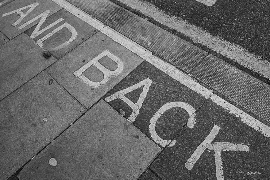 Writing on pavement (sidewalk) at bus stop '...AND BACK' Monochrome abstract landscape. © P.Maton 2014 eyeteeth.net