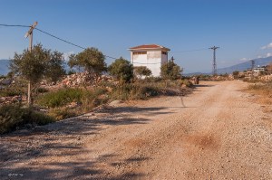 Overhead cables leading to solitary building by dirt road. Patara Turkey. Landscape Colour. P.Maton 2014 eyeteeth.net