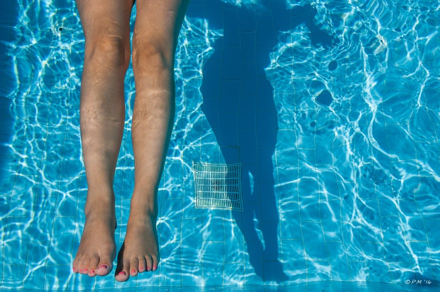Womans legs in swimming pool with shadow cast on pool floor. Colour abstract. P.Maton 2014 eyeteeth.net