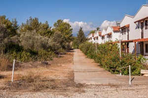 Empty new build housing block bordering olive trees and scrub. Patara Turkey. Landscape Colour. P.Maton 2014 eyeteeth.net