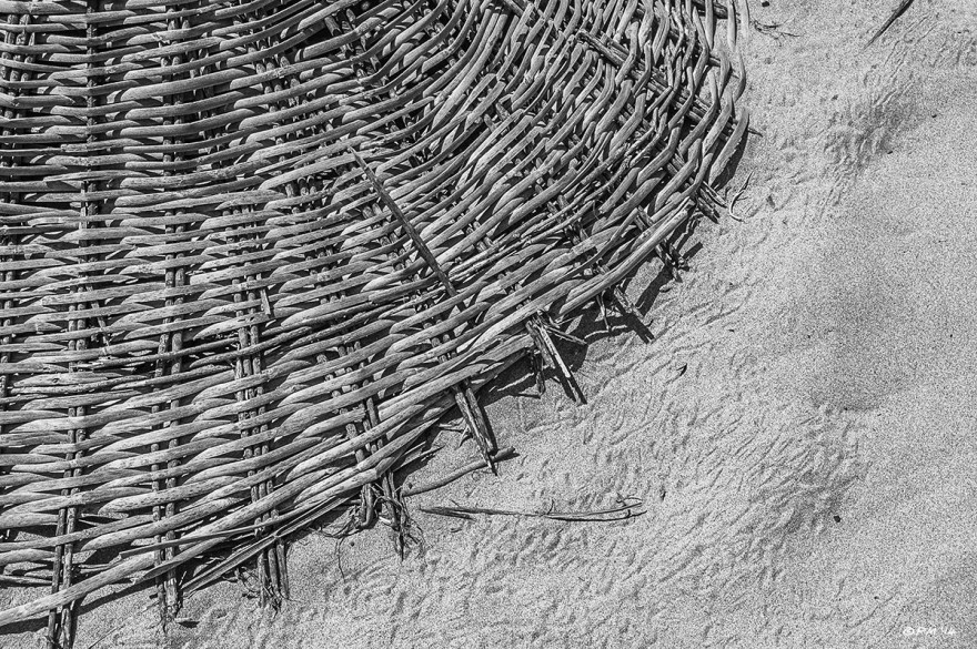 Woven Parasol sun shade lying on sand with crap tracks, Gelemis, Patara, Turkey. Abstract closeup monochrome. P.Maton 2014 eyeteeth.net