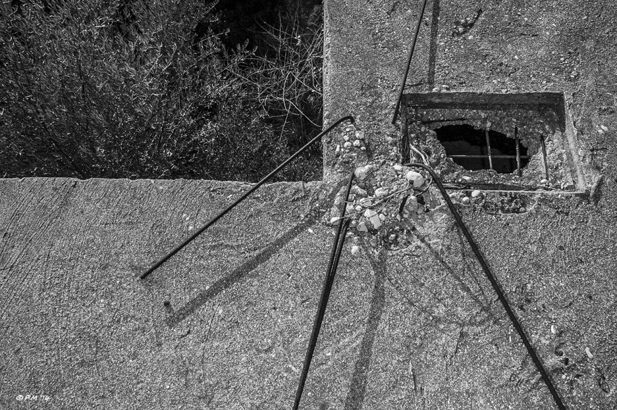 Bent rebar and square hole in concrete roof with olive trees below, monochrome abstract. Patara, Turkey. P.Maton 04/09/2014 eyeteeth.net