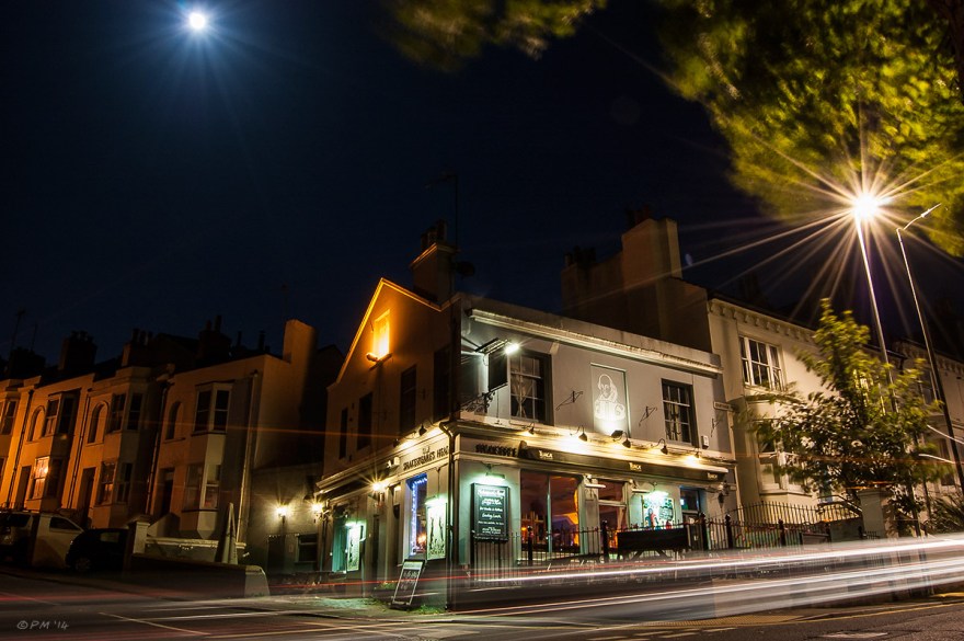 The Shakespere's Head Pub night at closing time illuminated by house lights, full moon, street lights and passing cars. Landscape Colour. © P.Maton 2014 eyeteeth.net