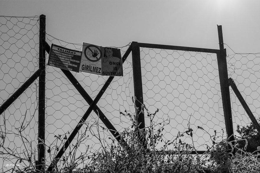 Fence with warning signs around archaeological dig of the Dynast Residence Patara Turkey. Monochrome landscape abstract.  © P.Maton 2014 eyeteeth.net