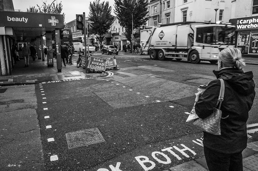 Woman stands at pedestrian crossing on an overcast day, London Road, Brighton UK. Monochrome Landscape. © P. Maton 2014 eyeteeth.net