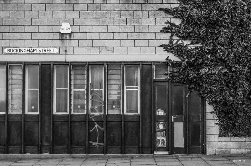 Concrete blocks, wooden door and windows with encroaching Ivy, Business building on corner of Buckingham Street, Brighton UK. Monochrome Landscape. © P. Maton 2014 eyeteeth.net