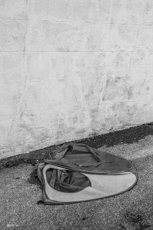Childs tent on asphelt pavement sidewalk beside  white wall. Monochrome Portrait abstract. G P. Maton 2014 eyeteeth.net