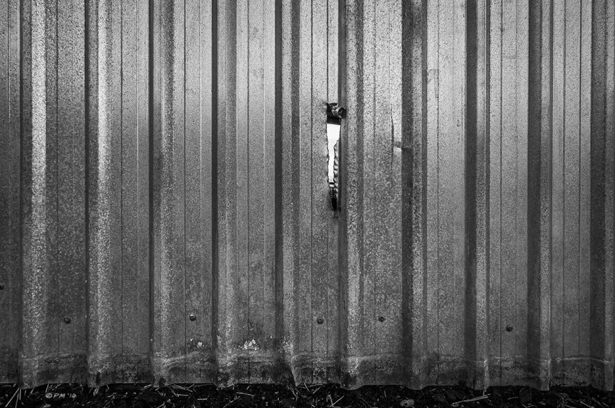 Hole torn in corrugated galvanised steel barn wall, Mohair Centre, East Sussex UK. Monochrome Landscape. © P. Maton 2014 eyeteeth.net 