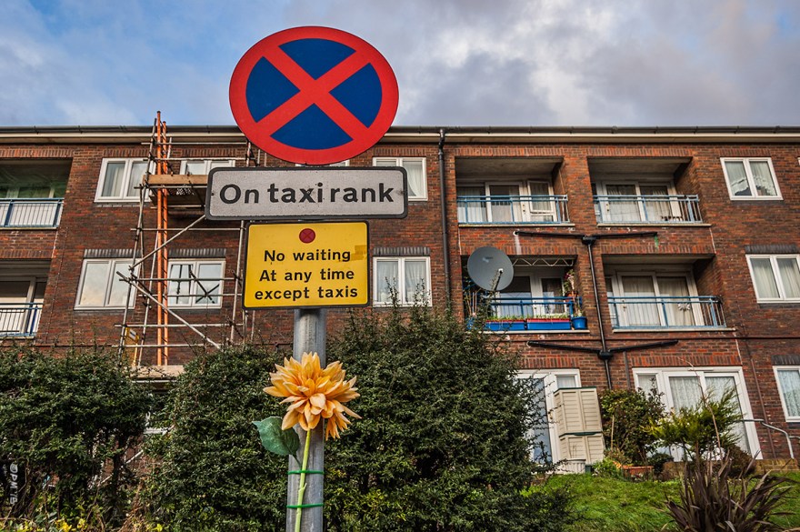 Taxi Rank sign with yellow plastic flower attached to post in front of flats. Portland Road, Hove UK. Colour Landscape. © P. Maton 2015 eyeteeth.net