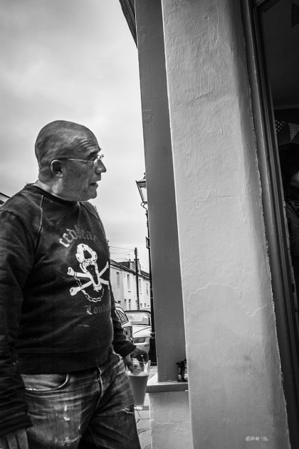 Man with pint of beer in hand looking into doorway. Trafalgar Street Brighton UK. Gloucester Road Brighton UK.Urban Street Photography. Monochrome Portrait. © P. Maton 2015 eyeteeth.net