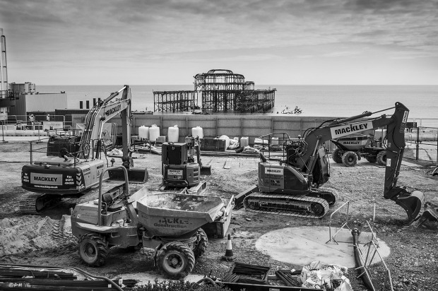 Heavy plant vehicles parked in construction site of i360 tower with West Pier ruins and sea in background, Brighton UK. Monochrome Landscape. © P. Maton 2015 eyeteeth.net