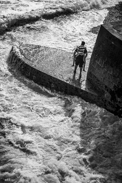 Boy carried of fathers back on ledge by sea. Brighton UK. Monochrome Portrait. © P. Maton 2015 eyeteeth.net