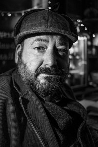 Man with beard and deerstalker hat sitting in a pub bar. Brighton UK Britain English culture and emotion. Black and white portrait photograph. © P. Maton 2016 eyeteeth.net