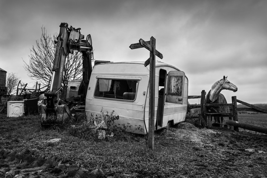 Abandoned caravan next to digger and horse by fence., rural black and white farm scene landscape, Poynings West Sussex UK. © P, Maton 2017 eyeteeth.net