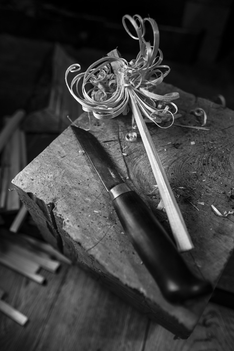 Finnish Puukko knife lying beside whittled feather stick on wooden block ©P. Maton 2017 eyeteeth.net