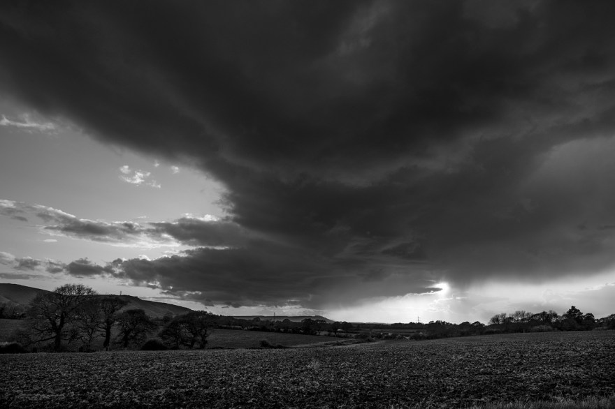 Sunset breaking through rain clouds by the South Downs with Chanctonbury Ring in distance, Poynings West Sussex UK black and white rural landscape  ©P. Maton 2018 eyeteeth.net
