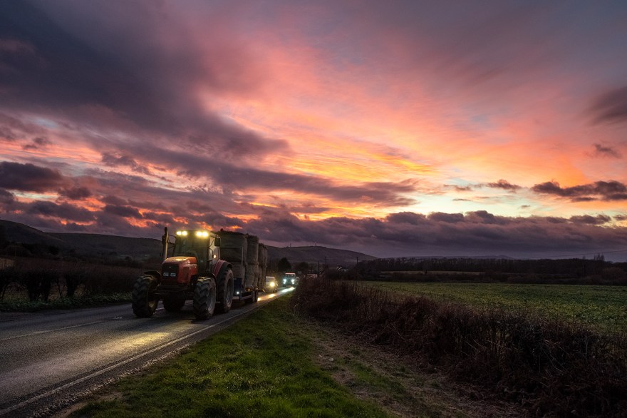 colourful sunset with tractor and headlights illuminating country road with south downs in background, rural west sussex landscape at dusk West Road, Newtimber ©P. Maton 2019 eyeteeth.net