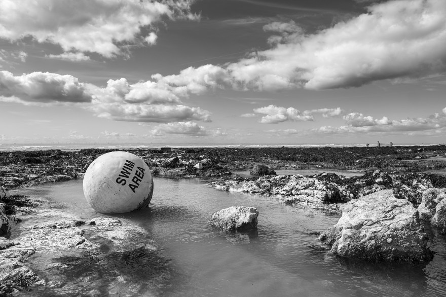 Swim Area Buoy caught in rock pool with dramatic clouds in sky Ovingdean East Sussex UK black and white landscape ©P. Maton 2019 eyeteeth.net